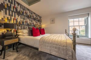 une chambre avec un lit avec des oreillers rouges et une fenêtre dans l'établissement Tern Cottage 6, à Burnham Market
