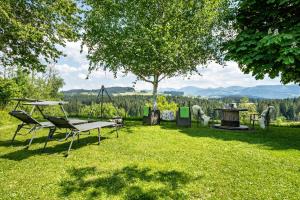 een picknicktafel en stoelen in een tuin met een boom bij Ferienwohnung Oberberg in Oberreute