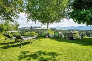 a picnic table and chairs in a yard with a tree at Ferienwohnung Oberberg in Oberreute