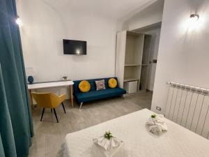 a living room with a blue couch and a table at I MORI - Holiday Rooms in Lascari