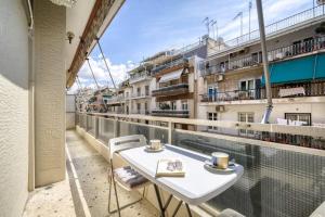 uma varanda com uma mesa e 2 chávenas de café em Μοντέρνο διαμέρισμα 2' από το μετρό em Atenas