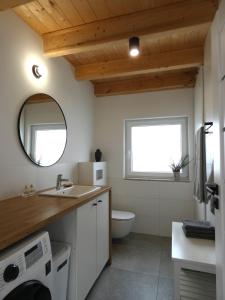 a bathroom with a sink and a toilet and a mirror at Domki Trzy - 2 in Smołdziński Las