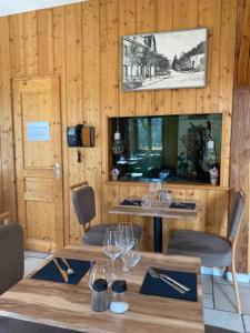 Chaux-des-CrotenayにあるHôtel Restaurant des Lacsのダイニングルーム(ワイングラス付きのテーブル付)