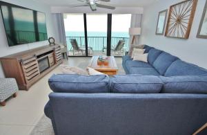 a living room with a blue couch and a tv at Daytona Ashley Penthouse 4 in Daytona Beach Shores