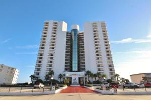 two tall white buildings with a red driveway in front at Daytona Ashley Penthouse 4 in Daytona Beach Shores