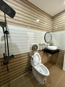 a bathroom with a toilet and a sink and a mirror at Khách sạn Anh Tuấn in Bạc Liêu