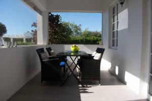 un patio con tavolo, sedie e finestra di 2 Bed 2bath Cottage Pickleball Court Pool a Providenciales