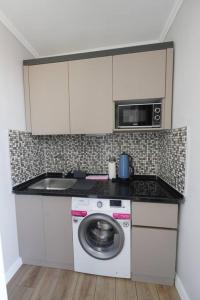 W kuchni znajduje się pralka i kuchenka mikrofalowa. w obiekcie Royal Homes 505 w mieście Antalya