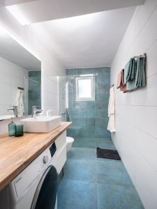 uma casa de banho com um lavatório e uma máquina de lavar roupa em Sunny side Apartments em Malinska