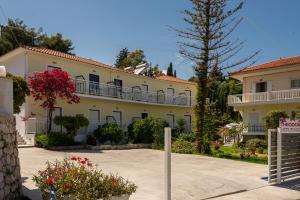 a large white building with balconies and flowers at Theodora Studios in Argassi