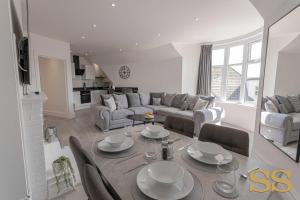 a living room with a table and a couch at Pearl Penthouse - 1 MINUTE FROM 02 ACADEMY - FREE PARKING - 5 MINUTES FROM THE BEACH - FAST WI-FI - SMART TV in Bournemouth