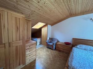 a bedroom with a bed and a chair in it at BovecApartmentA in Bovec