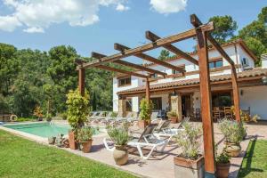 a patio with chairs and a pool in front of a house at Can Lari Chalet in Vall-Llobrega