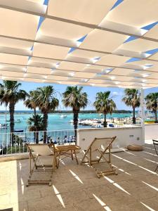 a patio with a table and chairs and a view of the beach at Casa Clementina Rooms vista mare in Porto Cesareo