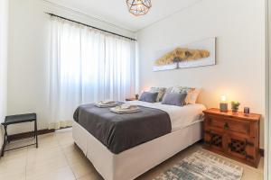 um quarto com uma cama grande e uma mesa em Vita Portucale ! Sandset Park View em Costa da Caparica