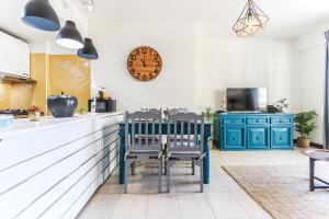 uma cozinha com armários azuis e um relógio na parede em Vita Portucale ! Sandset Park View em Costa da Caparica
