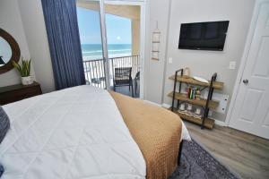 Un dormitorio con una cama y un balcón con vista al mar. en Oceania Plaza 502, en New Smyrna Beach 33 fotos más