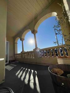 a porch with arches and a balcony with a plant at The Grayce Place. in Warrnambool