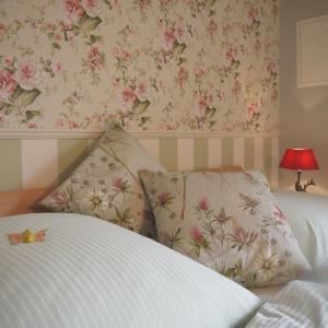 1 dormitorio con 1 cama con papel pintado de flores rosas en Inselferien Micheel, en Burg auf Fehmarn