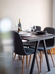 uma mesa de jantar preta com cadeiras e copos de vinho em Sunny side Apartments em Malinska