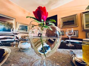 a red rose in a vase on a table at Opera Deluxe in Ravenna