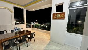 uma sala de jantar com uma mesa e uma varanda em Khách sạn Anh Tuấn em Bạc Liêu