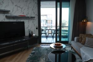 a living room with a couch and a tv and a table at Pullman Prime-I-BDROOM in Istanbul
