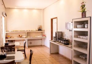 a kitchen with a counter and a table and chairs at Europa Hotel Brasília in Taguatinga