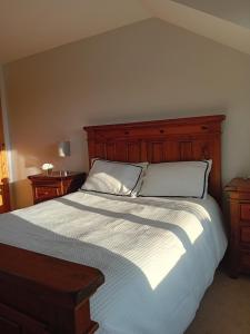 a bedroom with a large bed with a wooden headboard at The Red Door Townhouse Apartment in Ardara