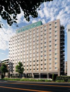 a hotel building with a sign on top of it at Hotel Route-Inn Nagoya Imaike Ekimae in Nagoya