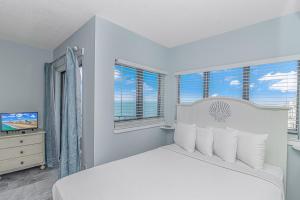 een witte slaapkamer met een bed en 2 ramen bij The Palace 1505 in Myrtle Beach