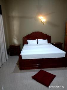 a bedroom with a large bed with white sheets at Tranquil at Airport Reach in Gonawala