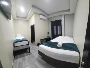 um quarto com duas camas e uma cadeira. em Mi Tierra Hotel y Restaurante em San Luis