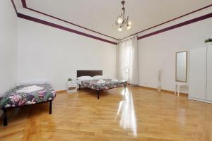 a large room with two beds and a wooden floor at Sanctuary Home 32 in Rome