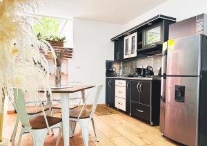 a kitchen with a table and a stainless steel refrigerator at 3BR/cozy house in the heart of Laureles in Medellín