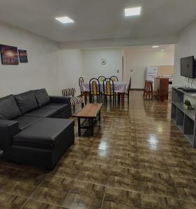 een woonkamer met een bank en een tafel en stoelen bij Alojamiento El Cóndor in Esquel