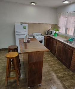 een keuken met een houten aanrecht en een koelkast bij Alojamiento El Cóndor in Esquel
