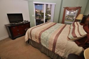 a bedroom with a bed and a flat screen tv at Oceanwalk 13-404 in New Smyrna Beach +65 photos