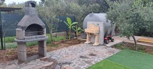 a garden with a stone oven and a statue at Casa Terra Del Sole in Pula