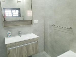 a bathroom with a sink and a mirror at JC Apartments in Ndola