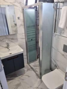 a bathroom with a sink and a shower with a mirror at Royal Homes 506 in Antalya