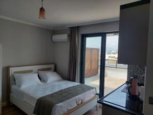 sypialnia z łóżkiem i balkonem z widokiem na okolicę w obiekcie Royal Homes 506 w mieście Antalya