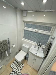 a small bathroom with a toilet and a sink at Self-Contained Ground Floor Flat in Nottingham
