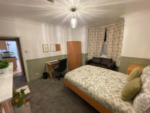 a bedroom with a bed and a desk and a chair at Self-Contained Ground Floor Flat in Nottingham