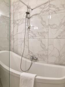 een badkamer met een bad en een douche met marmeren muren bij Lady Blue, villa à 15 mn plage à pied, parking, wifi, jardin in La Grande-Motte