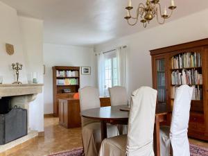 a dining room with a table and a fireplace at Lady Blue, villa à 15 mn plage à pied, parking, wifi, jardin in La Grande-Motte