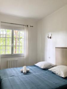 1 dormitorio con 1 cama con 2 toallas en Lady Blue, villa à 15 mn plage à pied, parking, wifi, jardin en La Grande-Motte