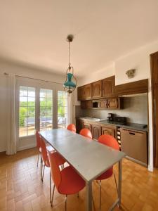 cocina con mesa de comedor y sillas naranjas en Lady Blue, villa à 15 mn plage à pied, parking, wifi, jardin en La Grande-Motte