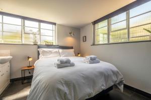 Un dormitorio con una cama blanca con toallas. en The Pump House, en Colchester