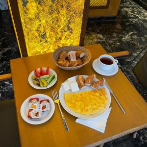 Gold Corner Hotel في إسطنبول: طاولة مع أطباق من طعام الإفطار وكوب من القهوة